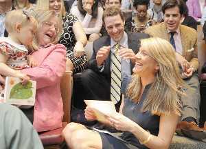 Nikki Alworth, right, opens her match letter as her husband, Chris Alworth, center, and her mother, Liz Sheridan, left, holding granddaughter Finley Alworth, rejoice that she'll be staying at the University of Maryland for her residency.