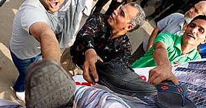 العشرات من أسر الشهداء يضربون صور مبارك بالأحذية